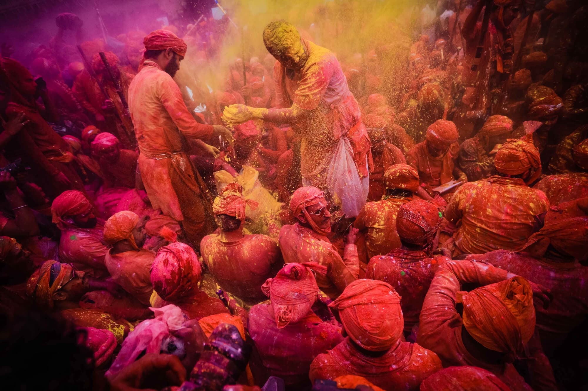 View of crowds of people covered in color during Holi, a Hindu spring festival. Photo by Bhupesh Pal