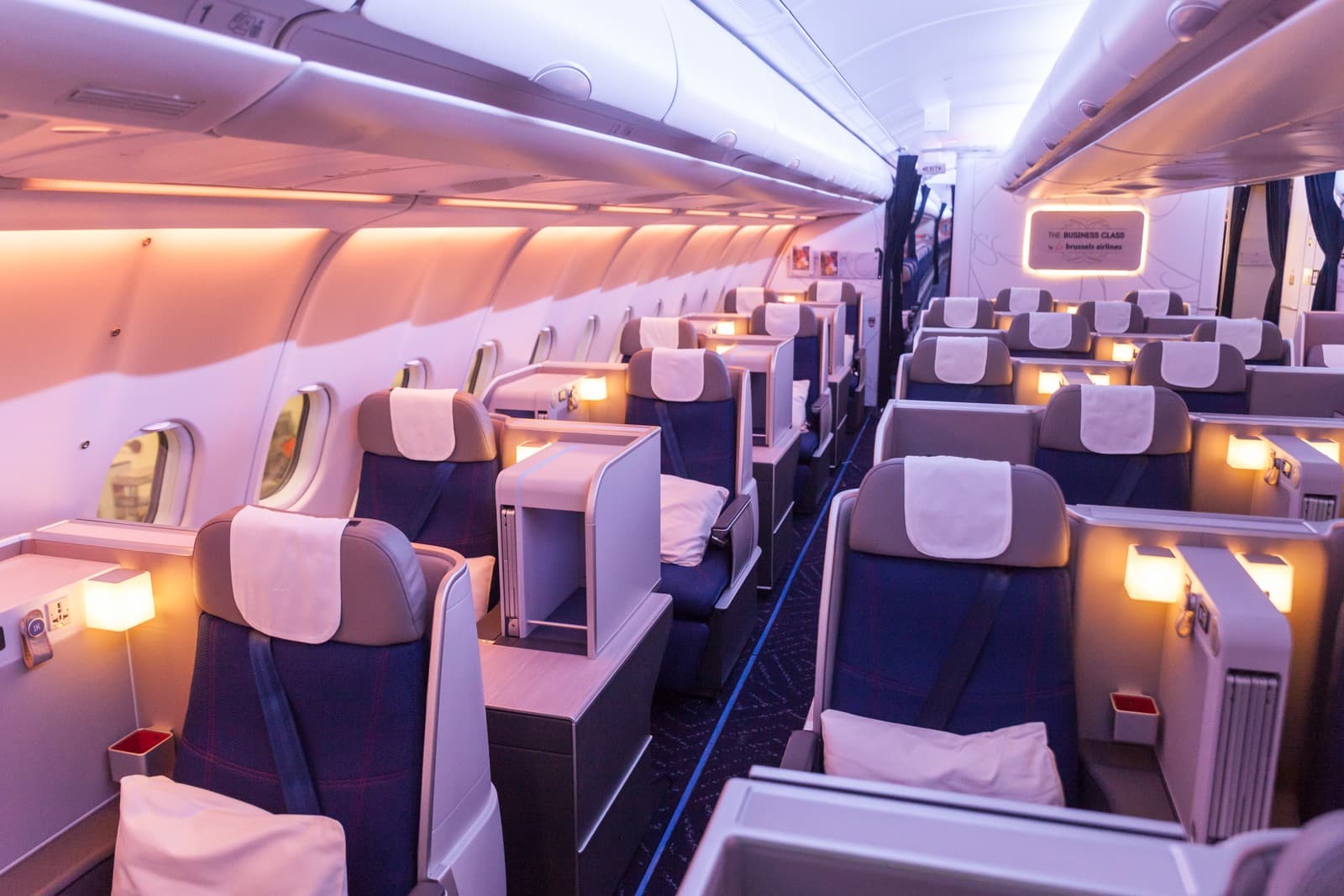 Brussels Airlines Business Class cabin aboard the Airbus A330, showcasing staggered seating and ambient lighting. Photo by Brussels Airlines.