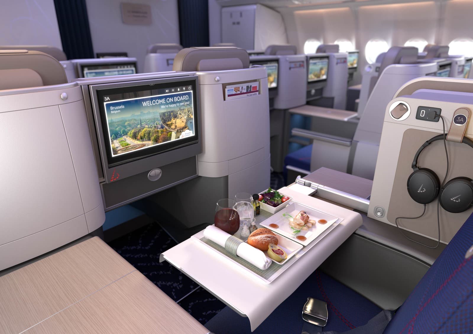 Brussels Airlines long-haul Business Class in-flight dining experience, complete with a multi-course meal and entertainment screen. Photo by Brussels Airlines.