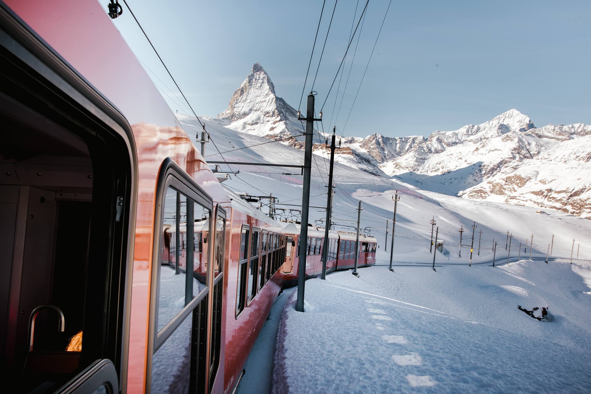 A train ascends the slopes in Zermatt, with the Matterhorn in the background, beauty of the Swiss Alps. Photo by Kevin Schmid