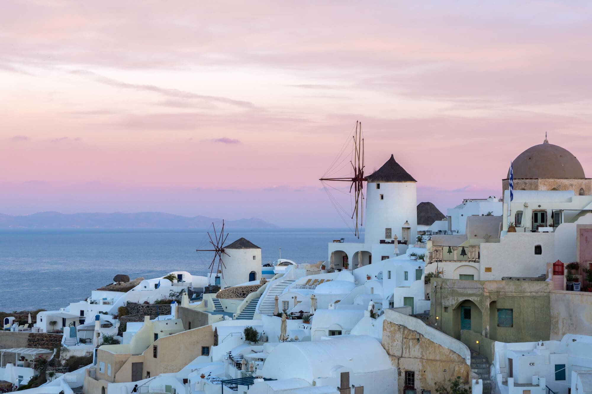 Sunset hues paint a picturesque view of Oia Village on Santorini Island.