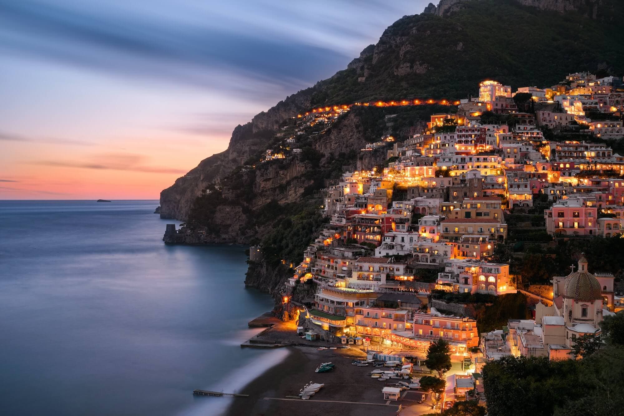 Fall in love with the charming village of Positano, as the evening blue hour paints a mesmerizing view of this Italian gem on the stunning Amalfi coast. Photo by Sebastian Leonhardt.