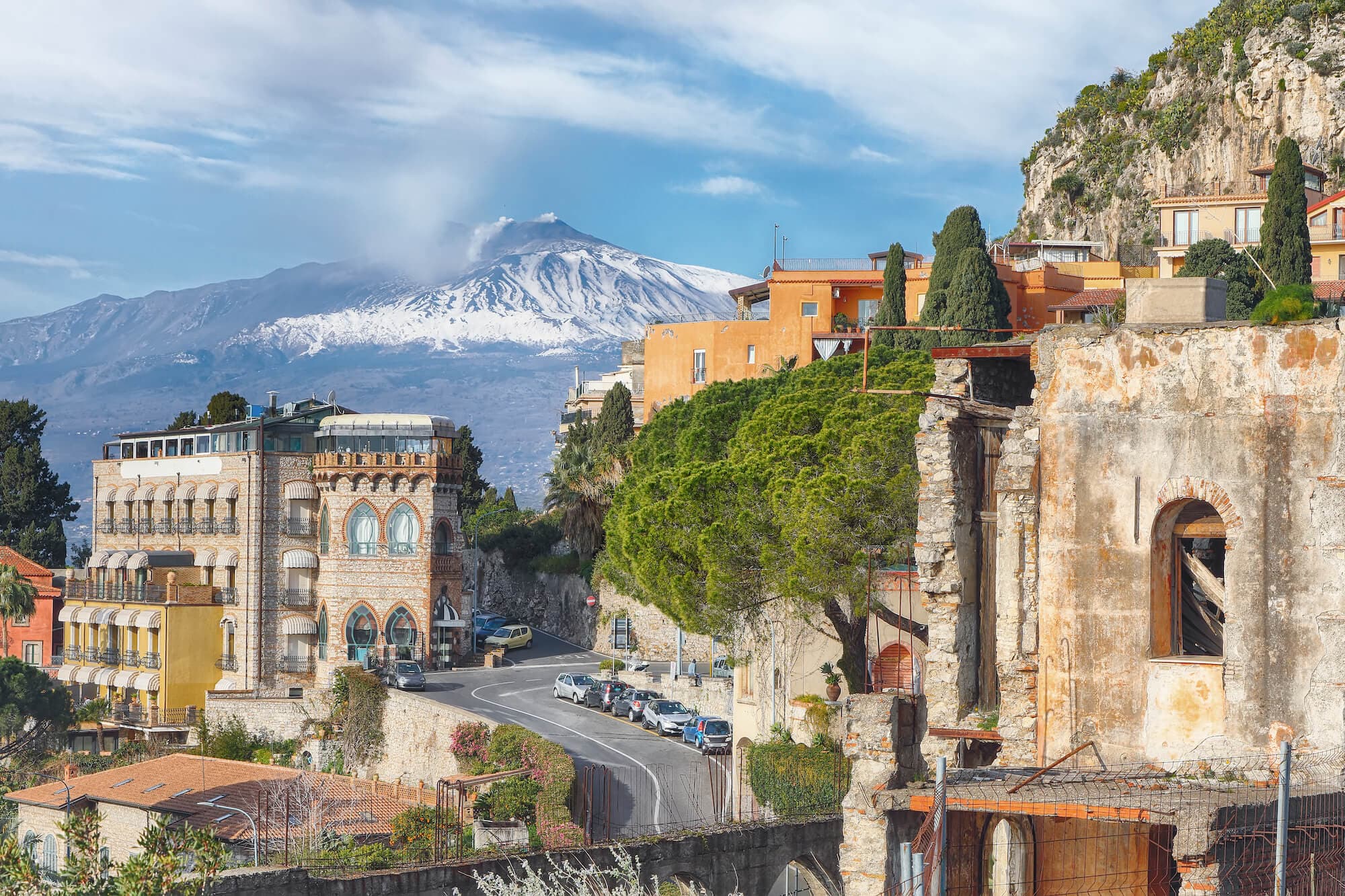 Panoramic view of Taormina town with the majestic Etna volcano in the background.