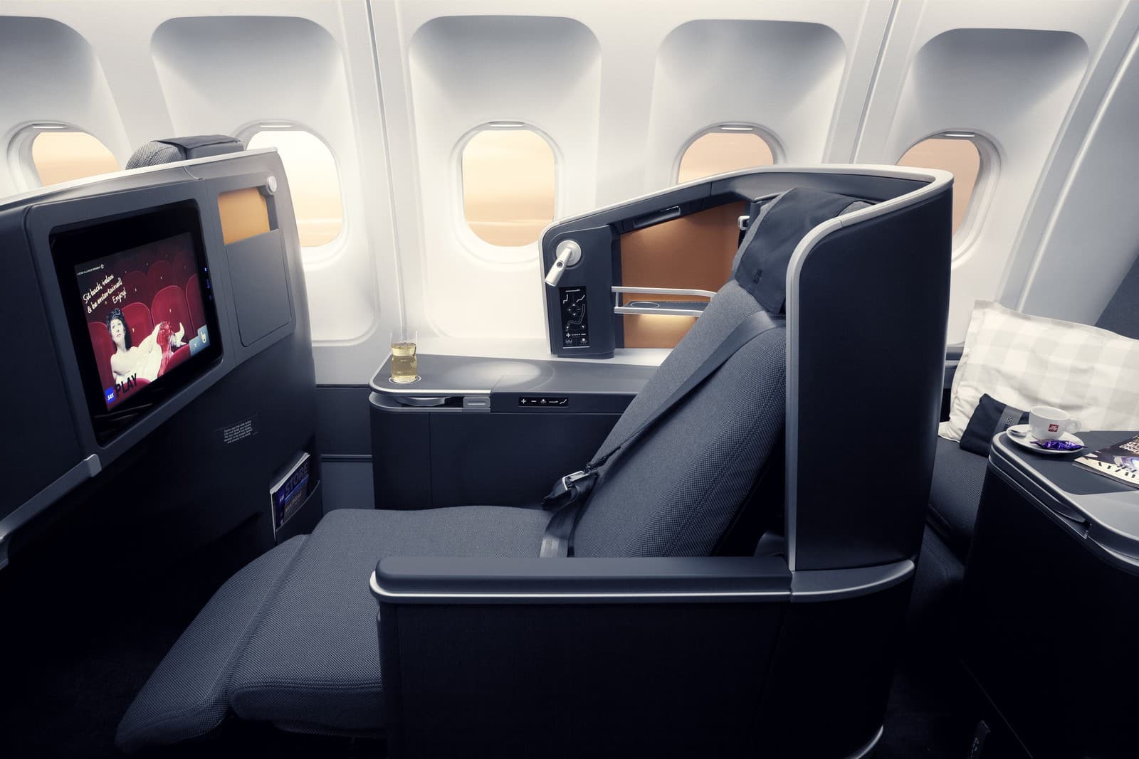 A comfortable window seat on the SAS A350 business class, featuring a fully flat bed, large entertainment screen, and ample surface space for personal items. Photo by SAS AB.