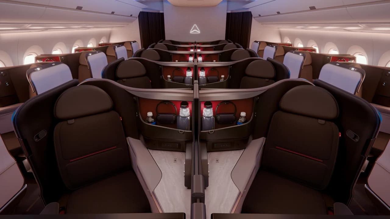 Delta One Suite with its signature navy leather and sliding privacy door — one of the first enclosed business class products