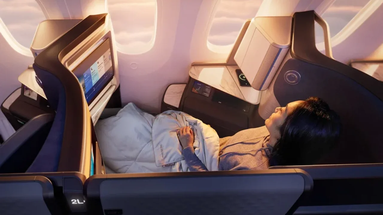 Business class cabin dimmed for an overnight transatlantic crossing — the right booking window puts you here for thousands less