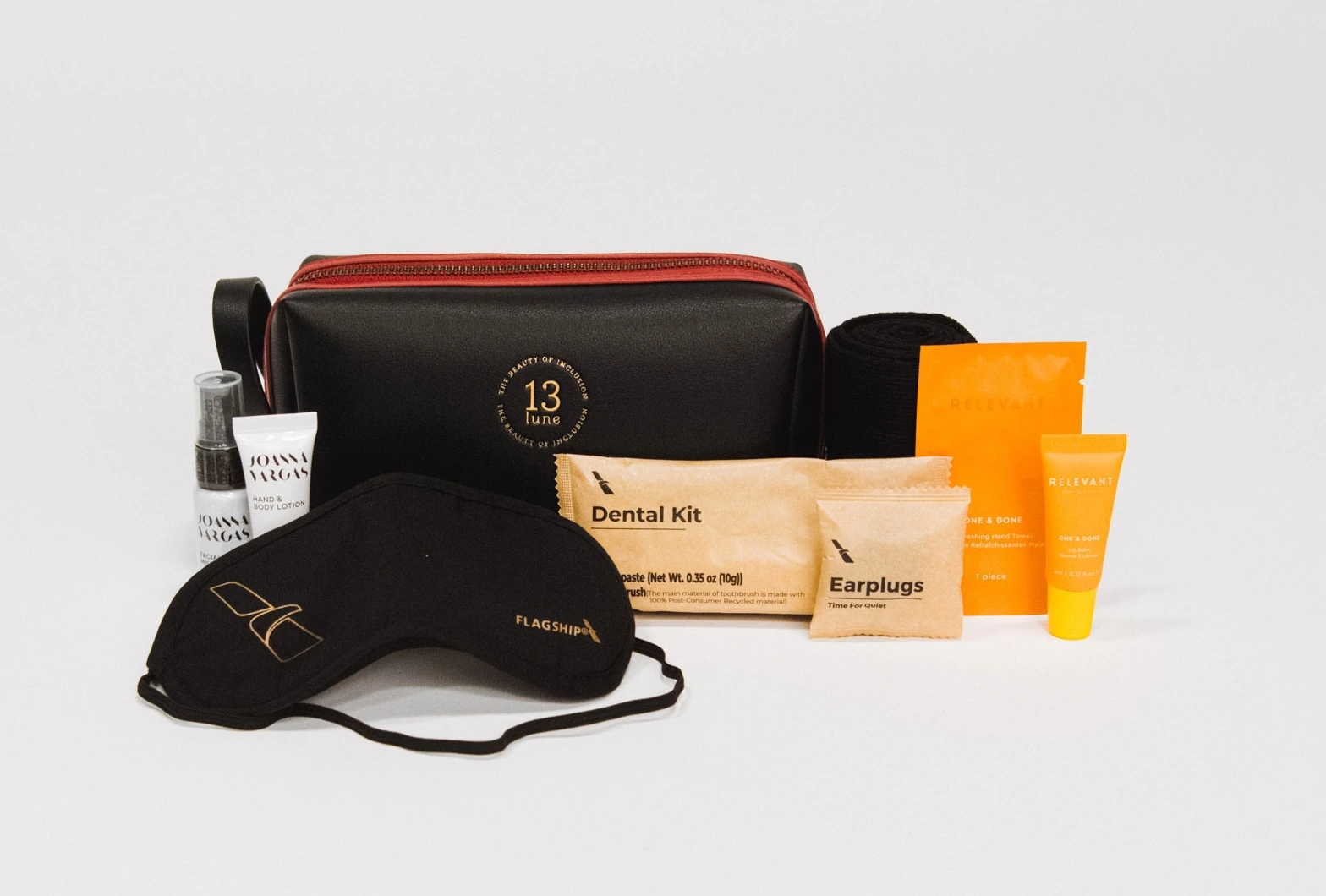 A premium business class amenity kit including skincare products, an eye mask, earplugs, and a dental kit.