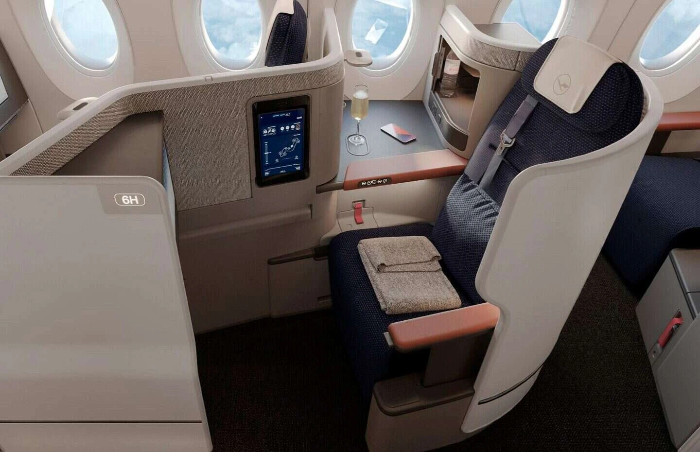 The Lufthansa Allegris business class seat features a large, stable tray table suitable for laptop use.